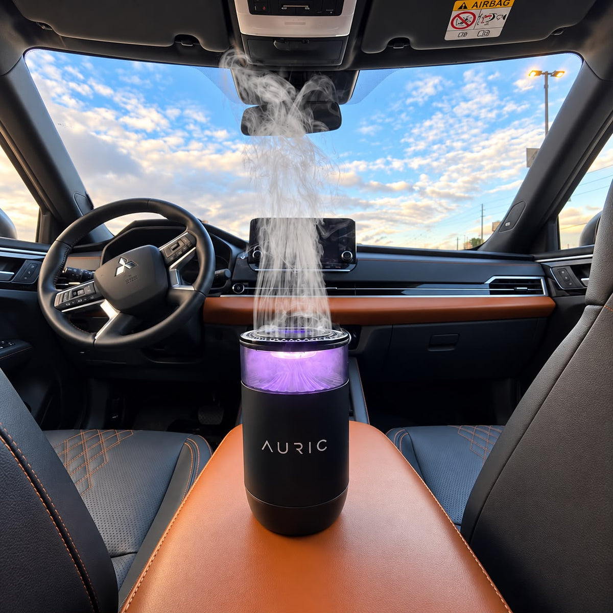 Difusor AURIC® LUXURY con luz violeta liberando vapor en el interior del auto